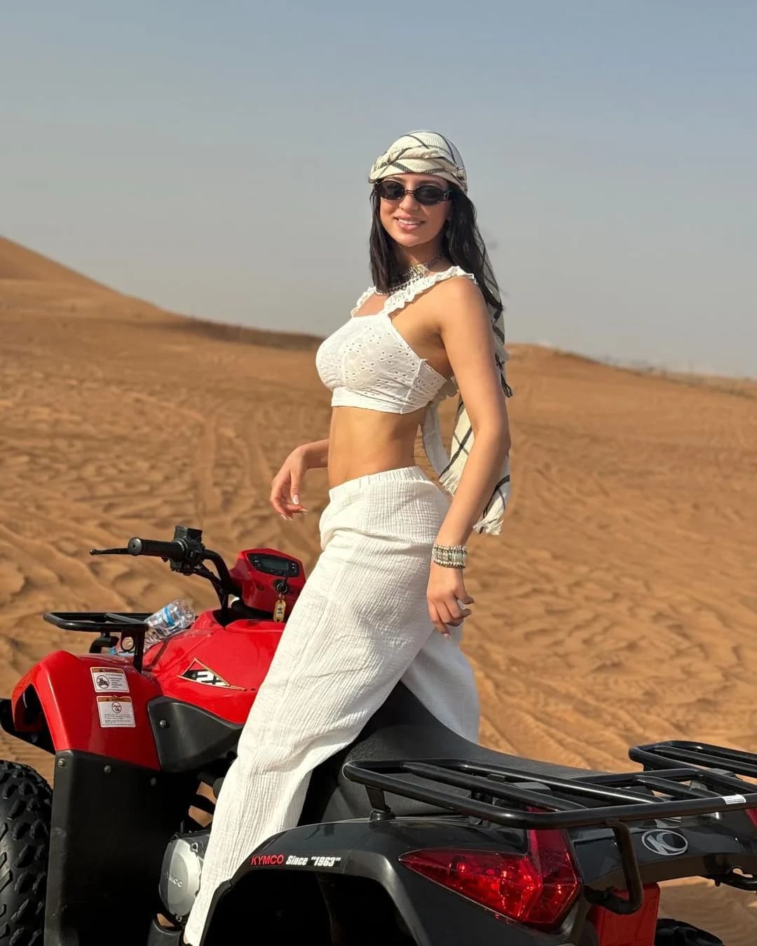 Guest posing on a red quad bike in the Dubai desert
