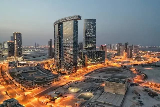 Abu Dhabi towers lit up at dusk