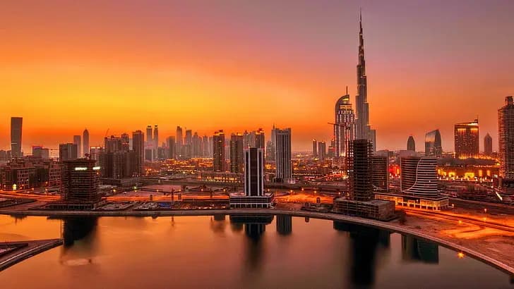 Burj Khalifa and the Dubai skyline at sunset over the creek