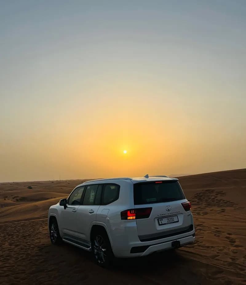 Safari 4x4 driving into the desert sunset