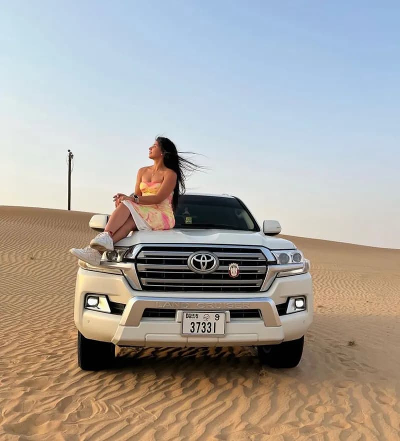 Guest sitting on the 4x4 sunroof in the dunes