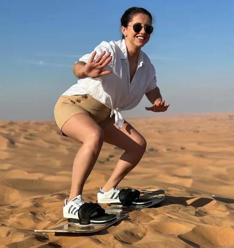 Guest sandboarding down the dunes