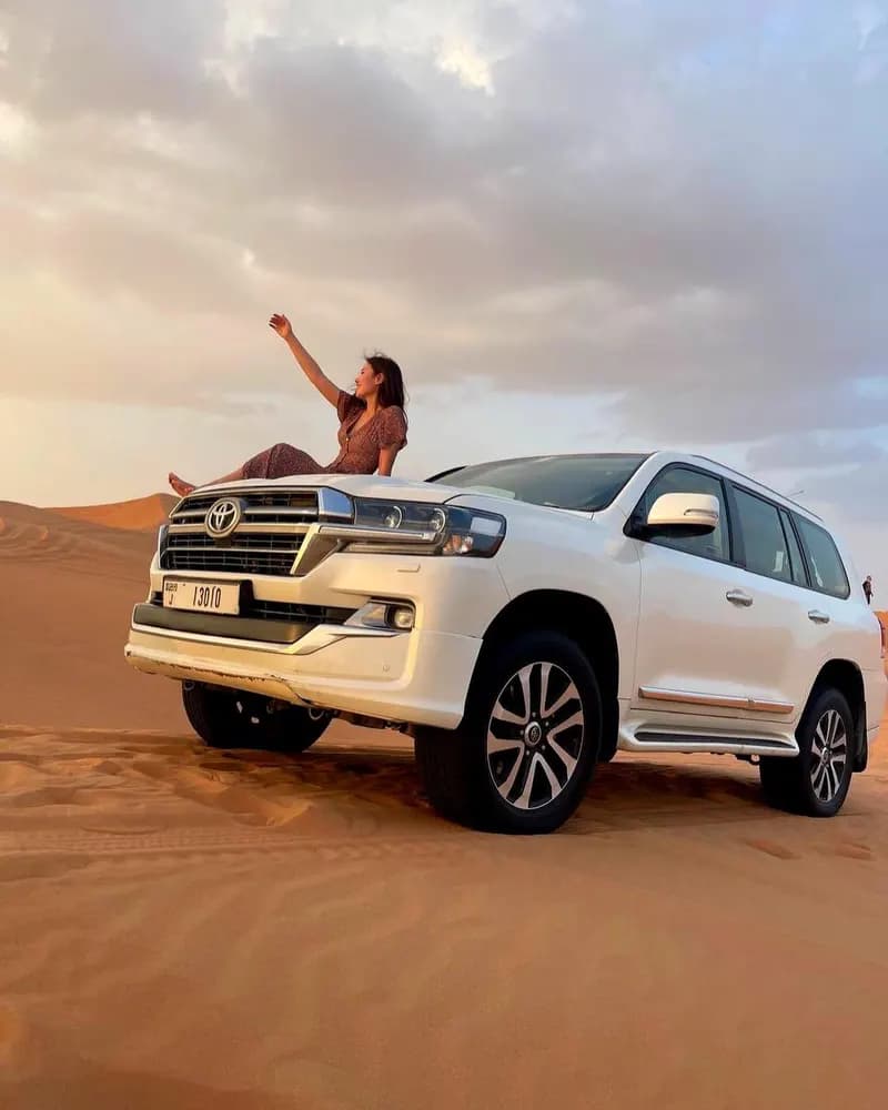 Guest waving from the 4x4 bonnet at sunset
