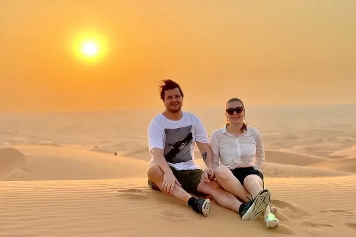 Couple enjoying the desert dunes at sunset