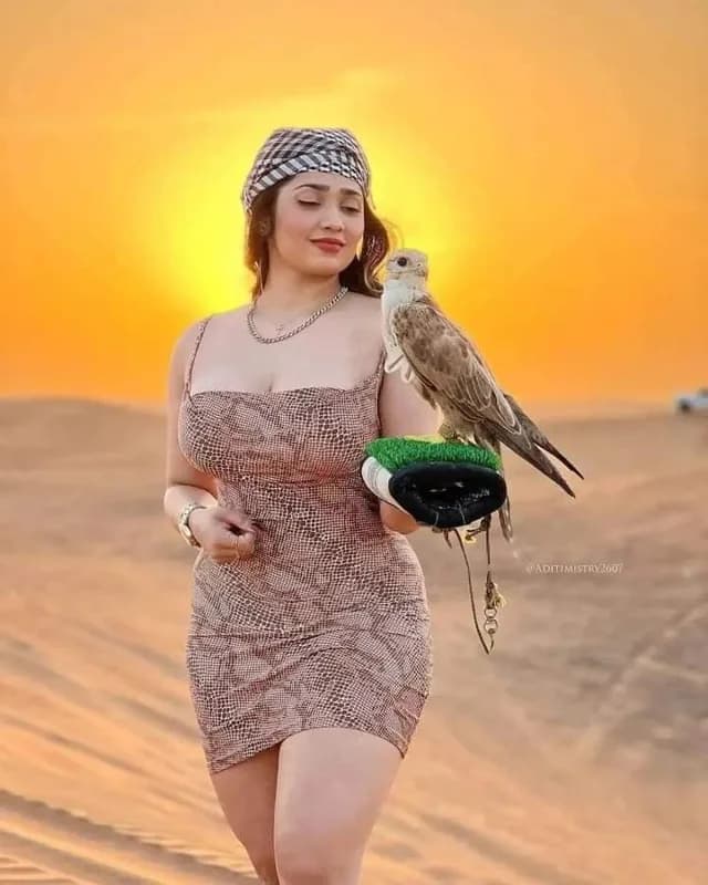 Guest posing with a falcon in the desert