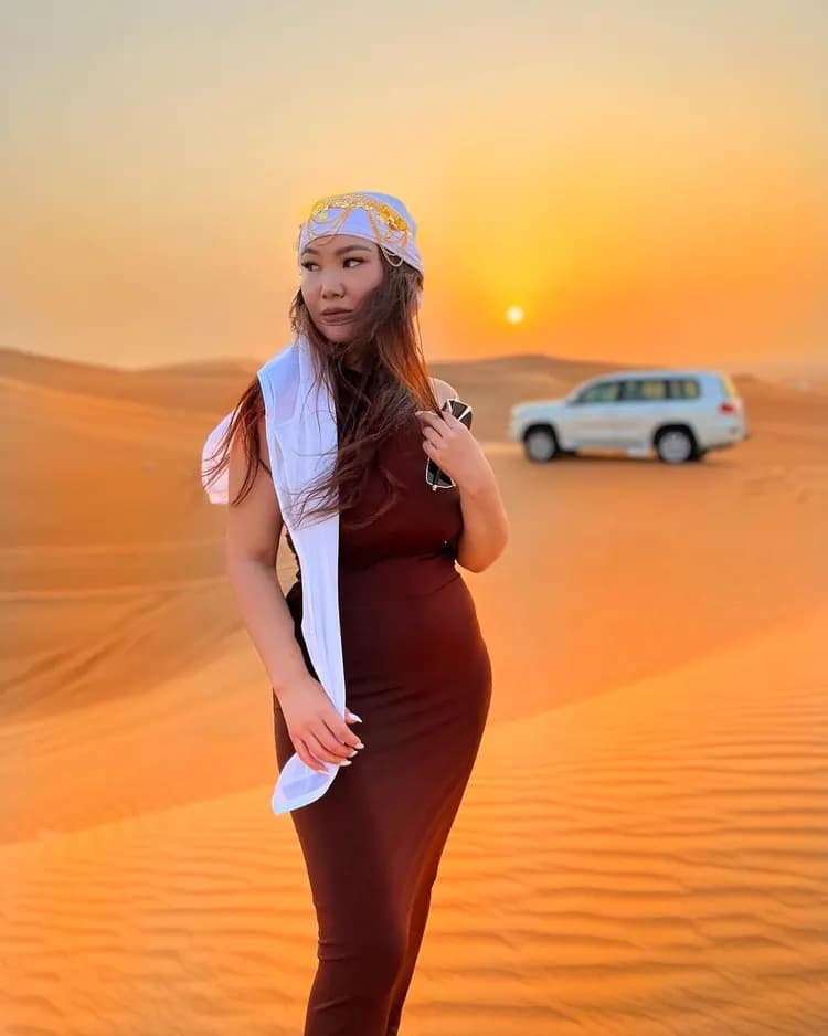 Guest in a headscarf on the dunes at golden hour