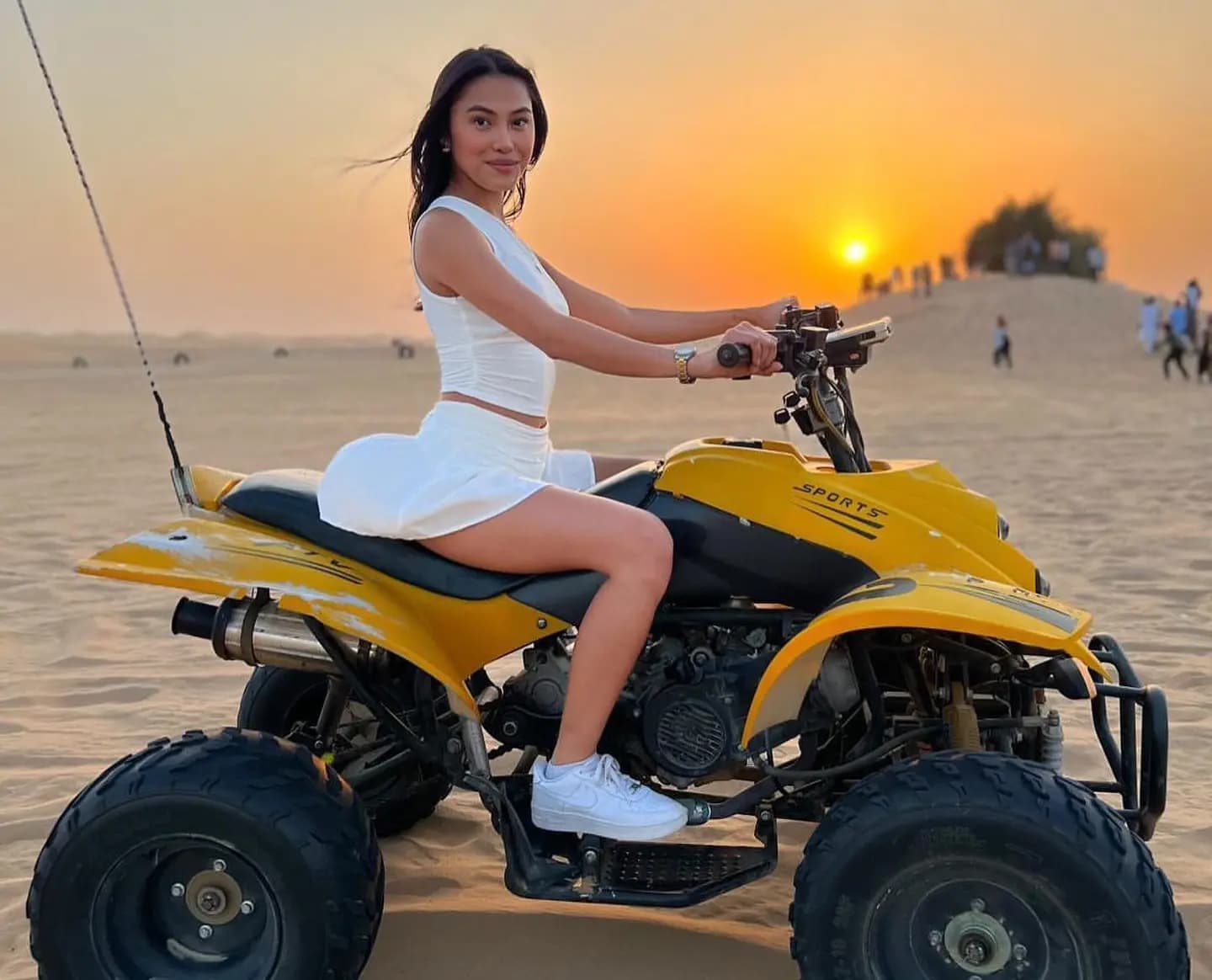 Guest seated on a yellow quad bike in the desert