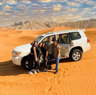Group beside a white 4x4 on the dunes