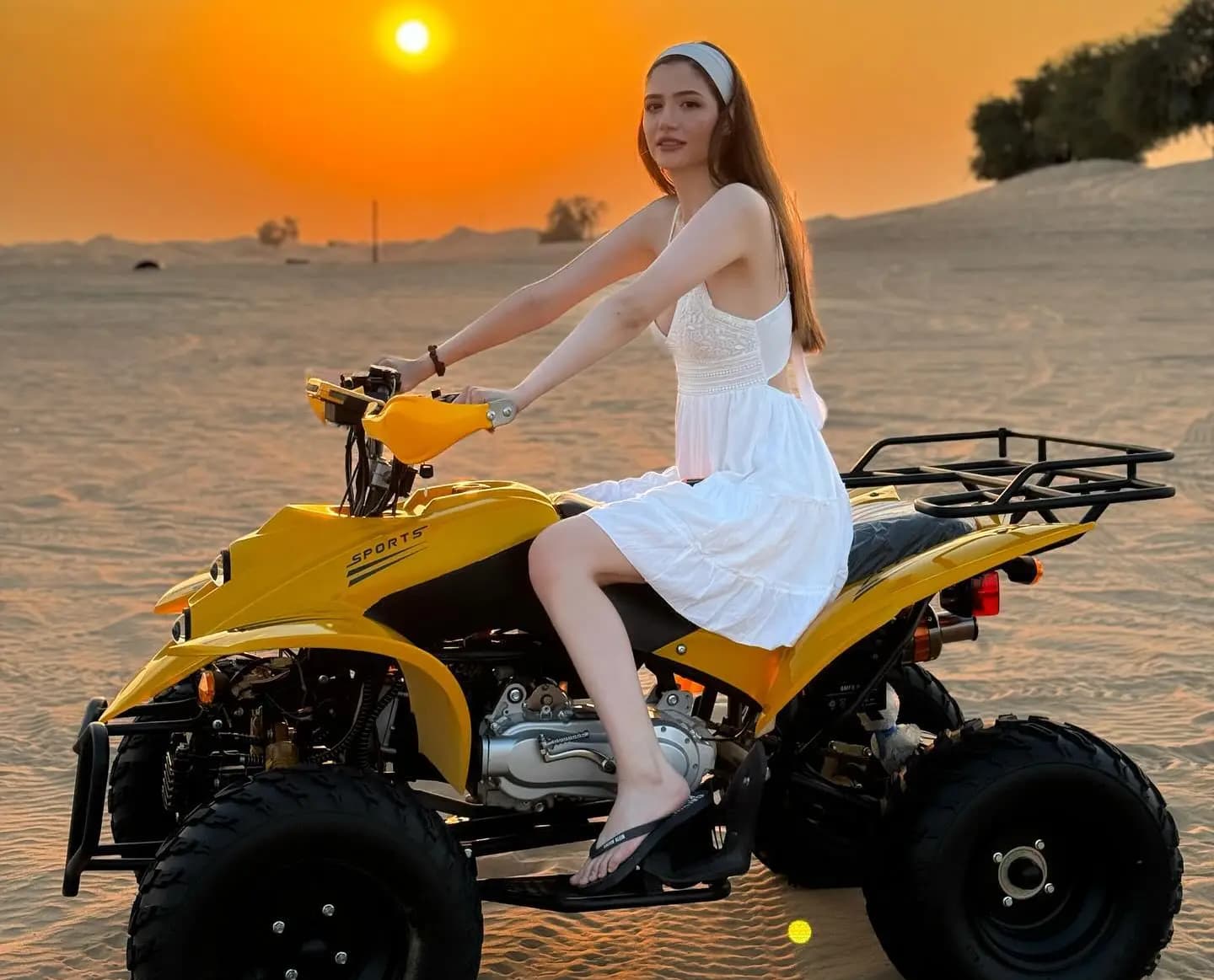 Guest riding a yellow quad bike at sunset