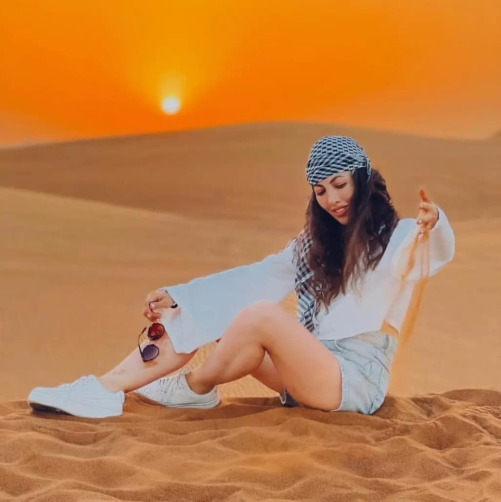 Guest relaxing on the dunes at sunset