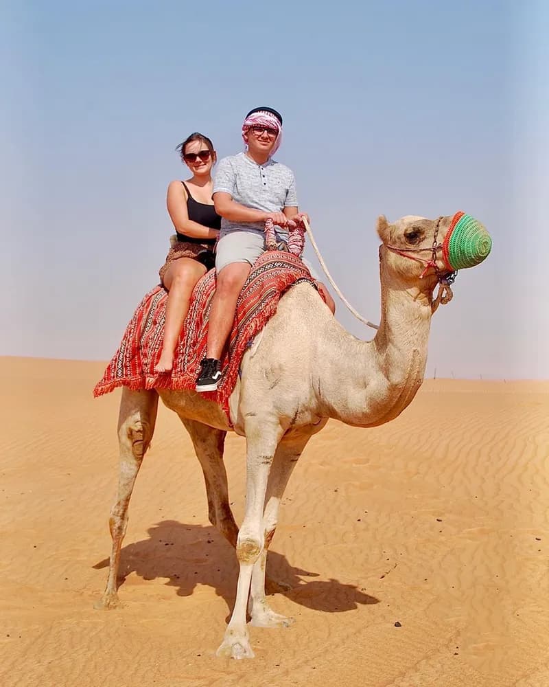 Couple enjoying a camel ride in the desert