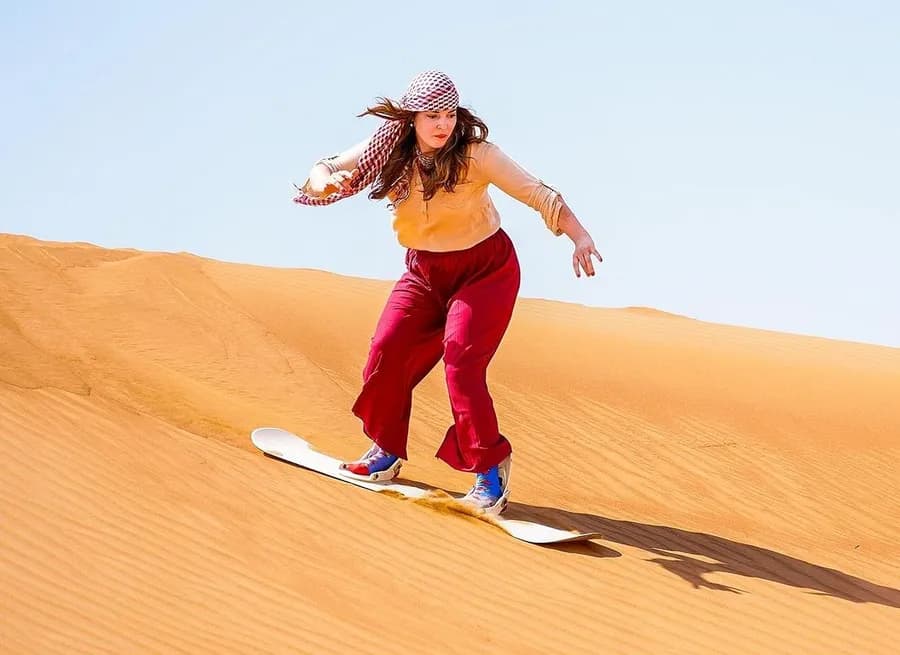 Sandboarding down the dunes at golden hour