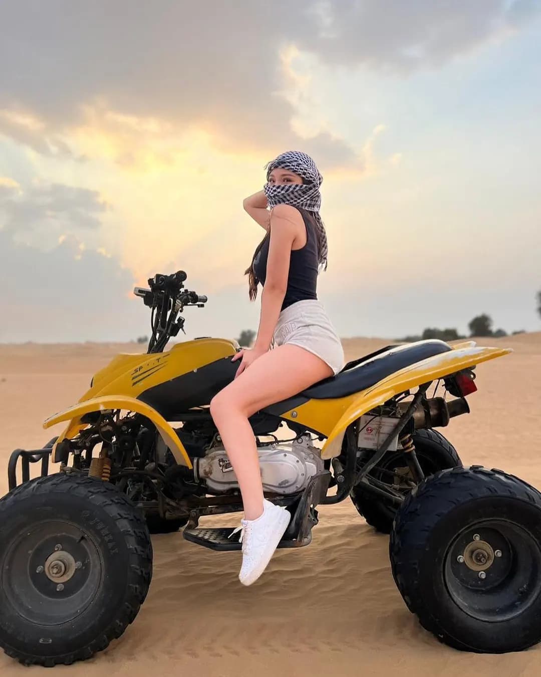 Guest sitting on a yellow quad bike in the desert