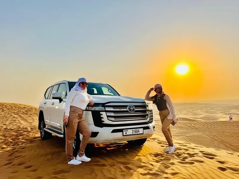 Couple posing beside their private safari 4x4 at sunset