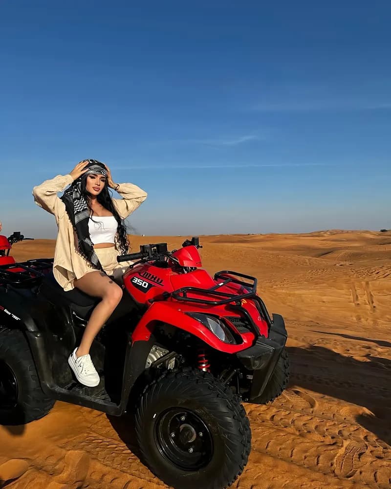 Guest posing on a quad bike in the desert