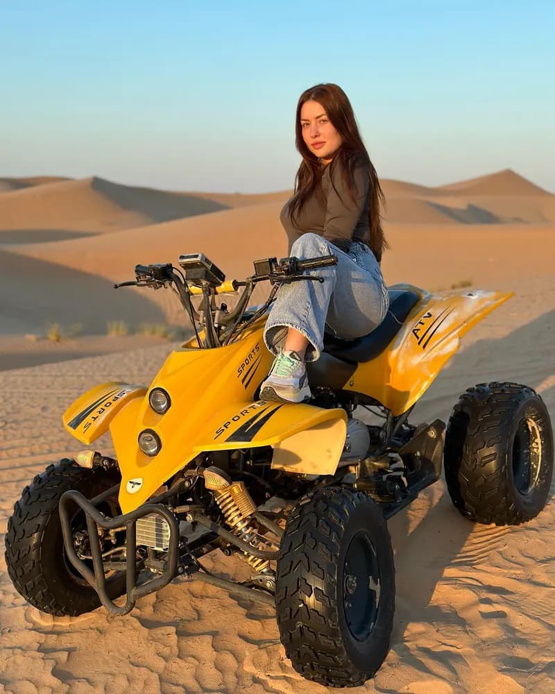 Guest posing on a quad bike in the desert