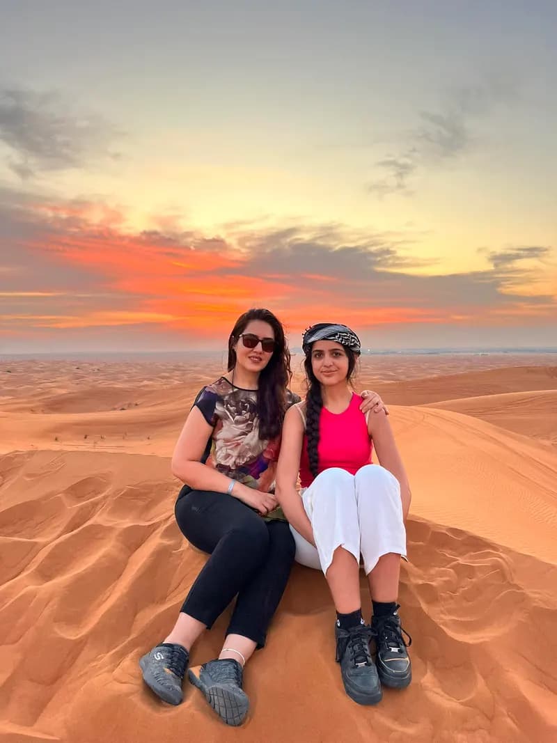 Friends sitting together on the dunes at sunset