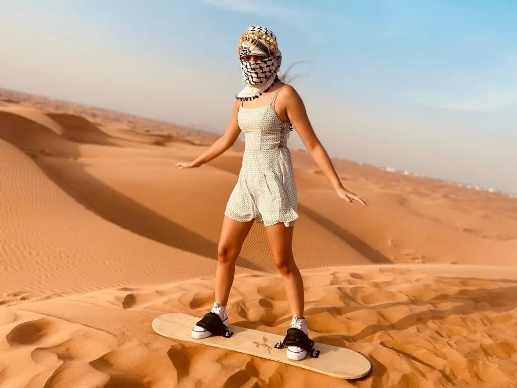 Guest sandboarding down the dunes