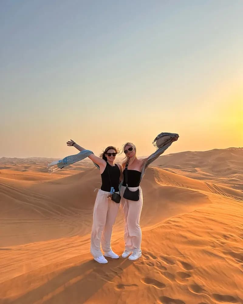 Friends celebrating on the dunes at sunset