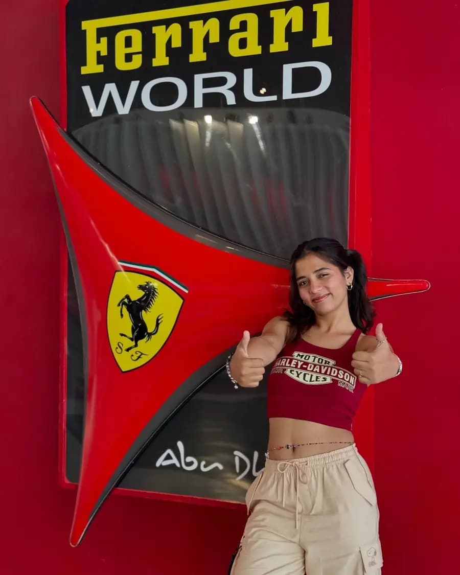 Visitor beside the Ferrari World logo wall