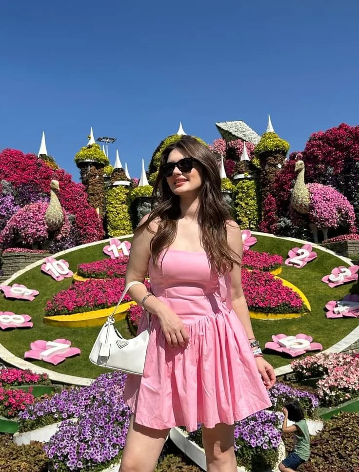 Guest standing on the garden's flower clock display