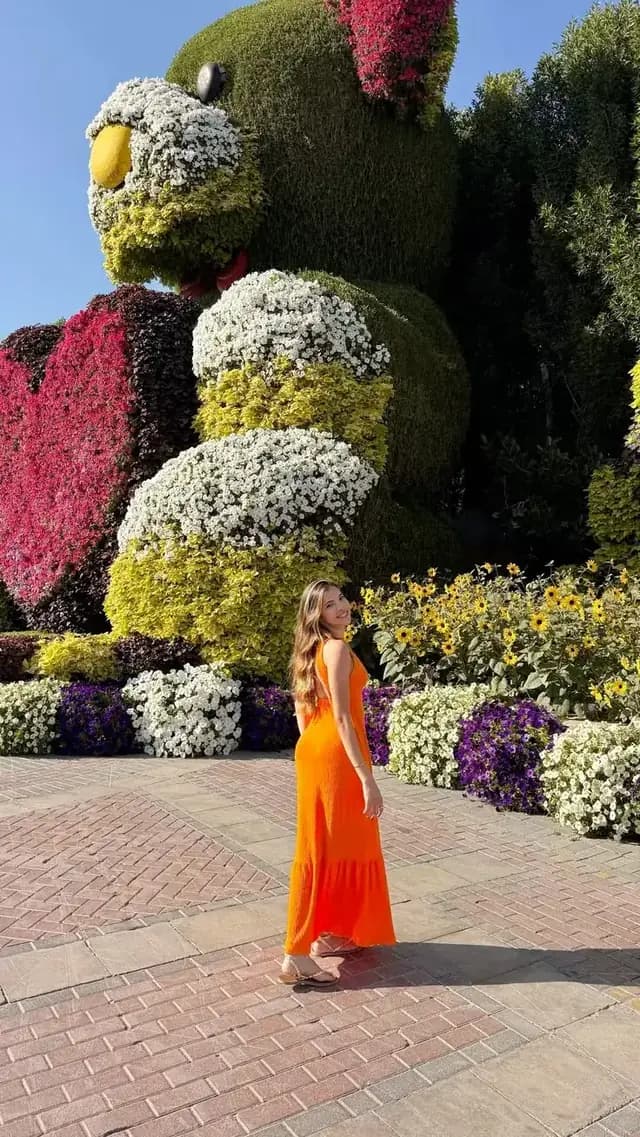 Guest beside a tall bird topiary