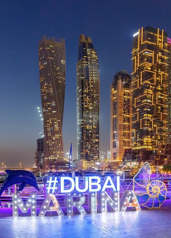 Dubai Marina skyscrapers lit up at night along the waterfront