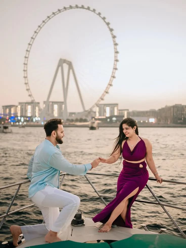 Couple on deck at golden hour with Ain Dubai behind
