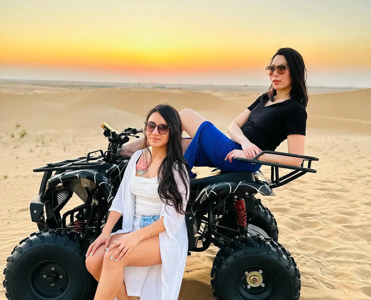 Two guests seated on quad bikes in the desert
