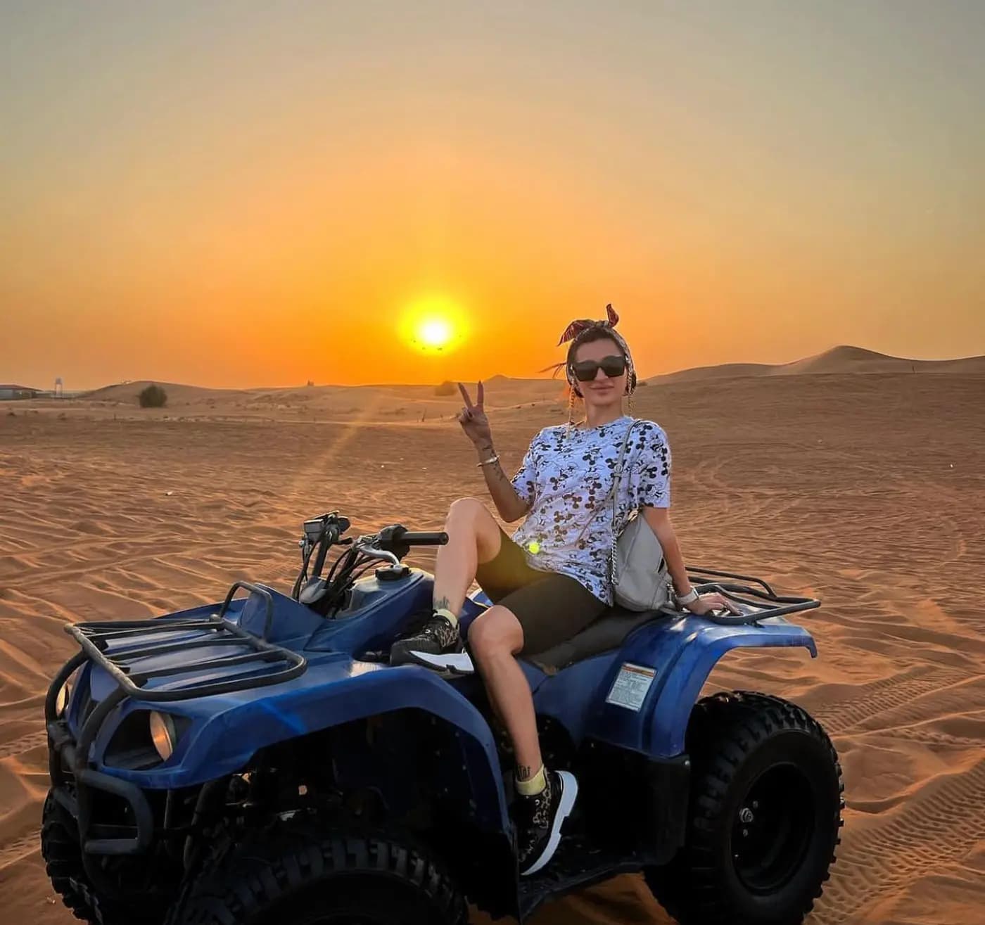 Rider pausing on a quad bike as the desert sun sets