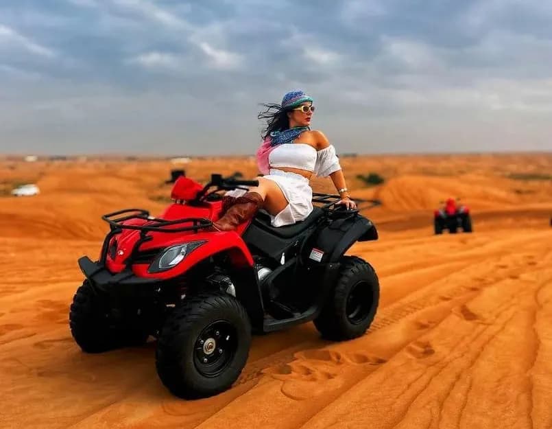 Guest raising an arm on a red quad bike